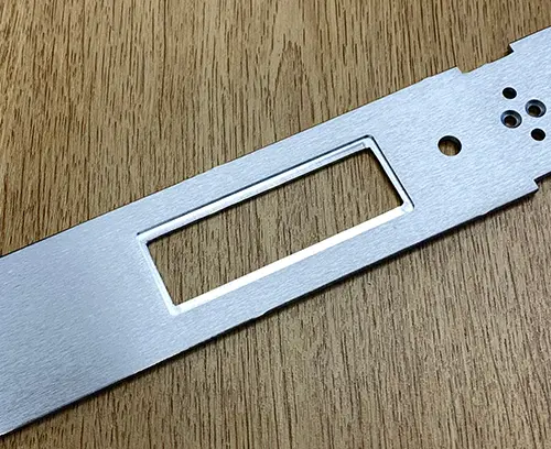 Encoche usinée à l'arrière d'une découpe rectangulaire perforée pour la localisation d'un module d'affichage.